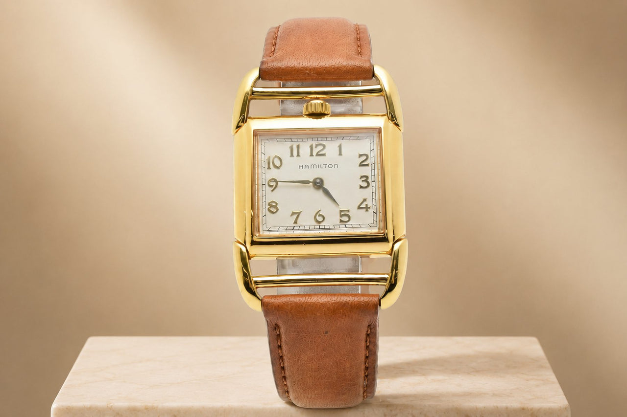 Vintage Hamilton square-case watch with a white dial and gold numerals on
a tan strap