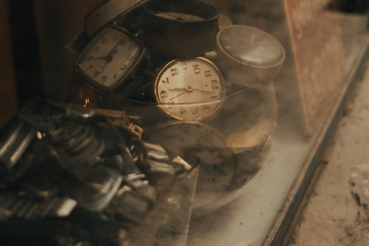 Vintage clocks and watch dials collected in an antique shop window